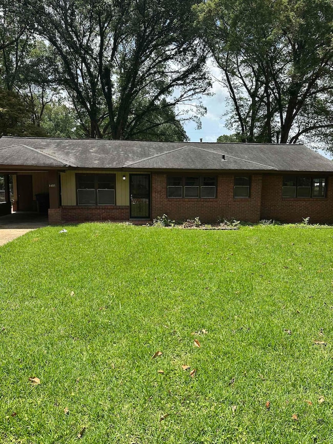 Ranch-style home with an attached carport, driveway, a front lawn, and brick siding