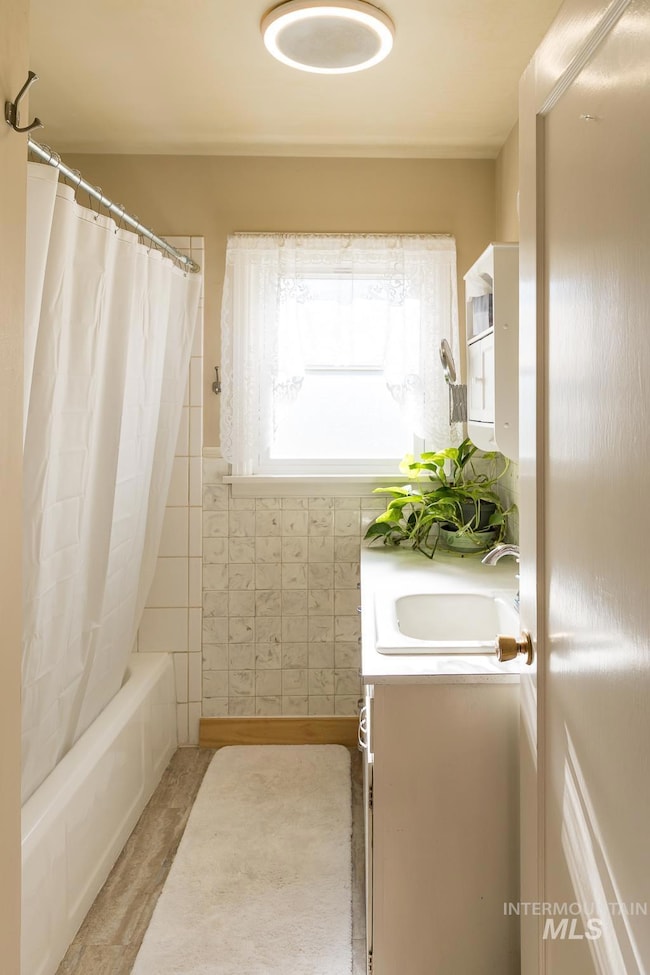 Bathroom with vanity and shower / bathtub combination with curtain