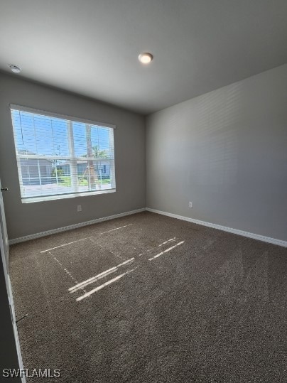 Empty room featuring baseboards and carpet