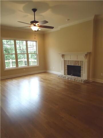 From the entry foyer, you will find the great room. It is complete with stone fireplace, gleaming hardwoods and triple windows for great natural lighting. There is ceiling fan lighting as well as recessed lighting is this large room.