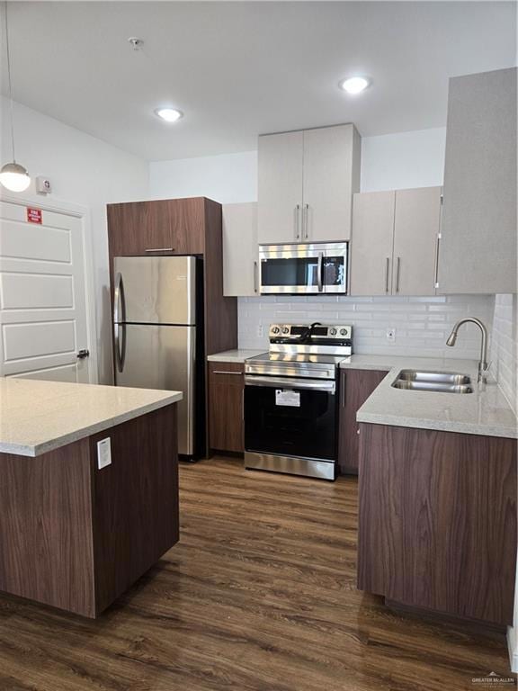 Kitchen featuring refrigerator, stainless steel range with electric stovetop, dark wood-type flooring, decorative backsplash, and a sink