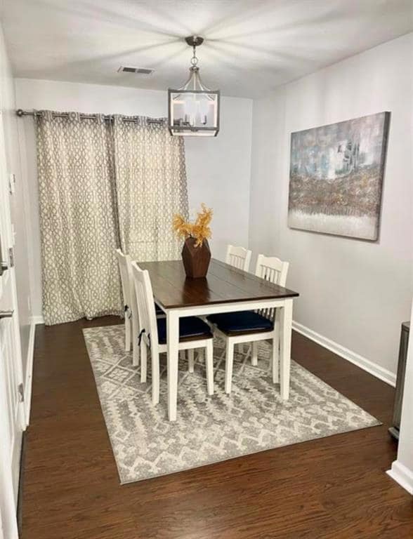 Dining space with a chandelier, wood finished floo
