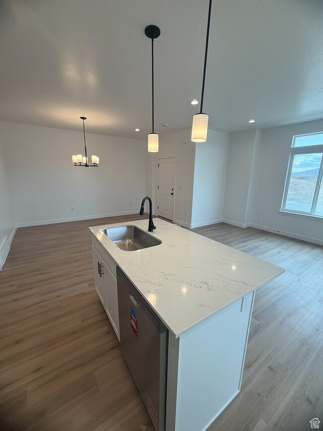 Kitchen featuring open floor plan, hanging light fixtures, dark wood-style flooring, dishwasher, and recessed lighting