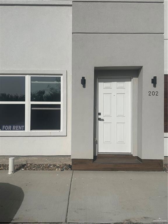 Doorway to property featuring stucco siding