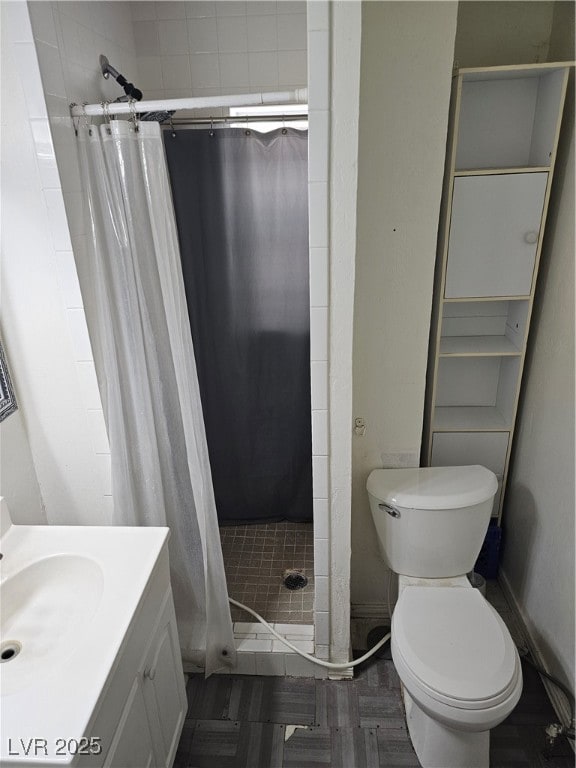 Bathroom featuring a stall shower, baseboards, toi