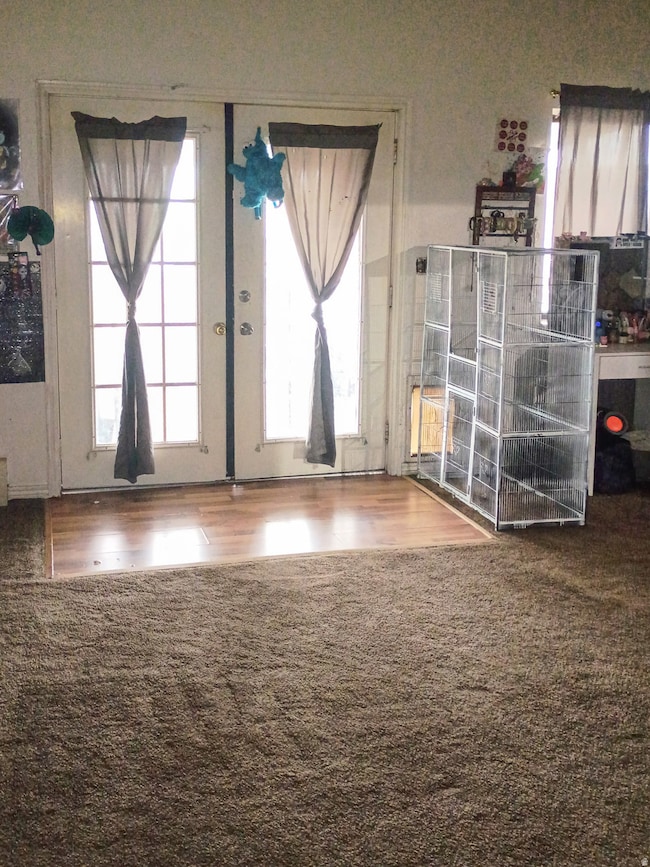 Entryway with wood finished floors, carpet floors, and french doors