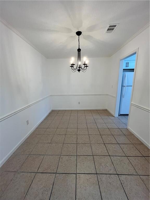 Unfurnished dining area featuring baseboards, ligh
