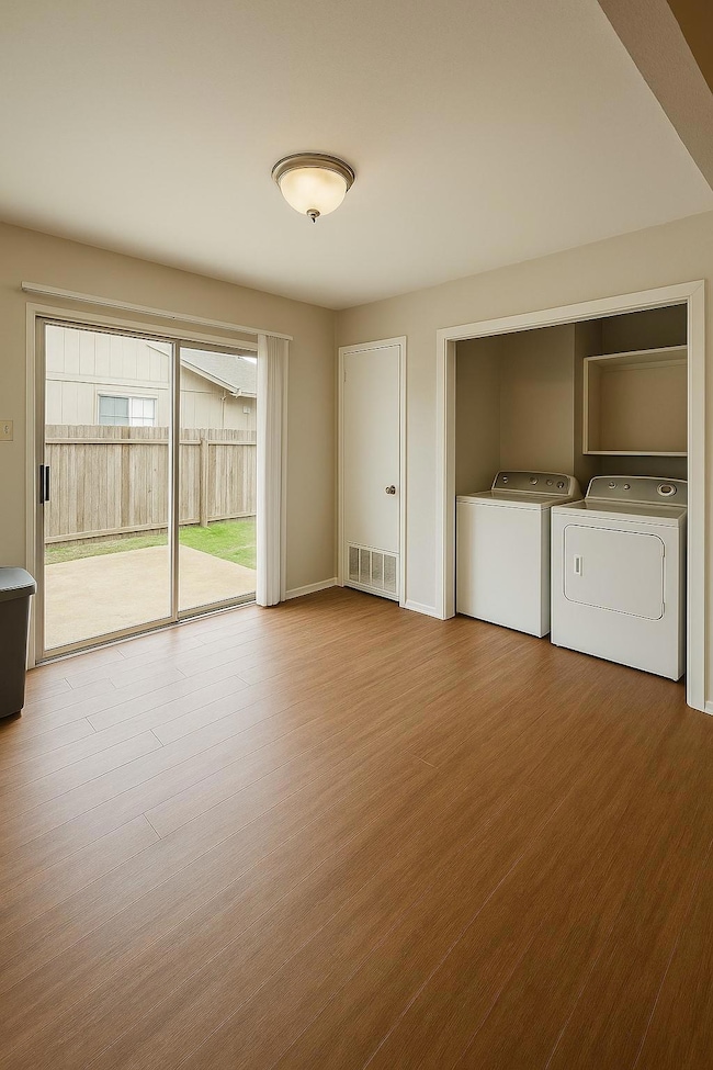 Laundry area with wood finished floors and indepe