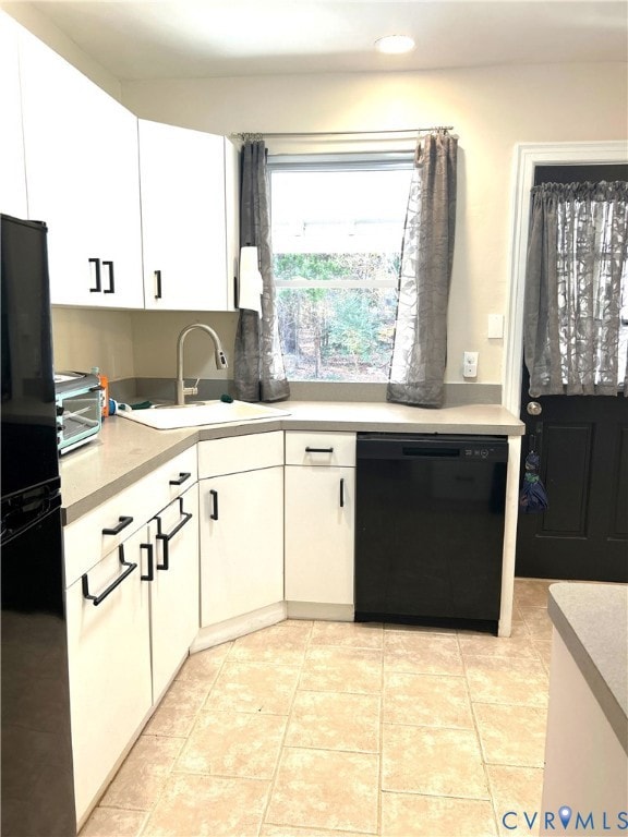 Kitchen featuring white cabinets, black appliances, light countertops, light tile patterned floors, and recessed lighting