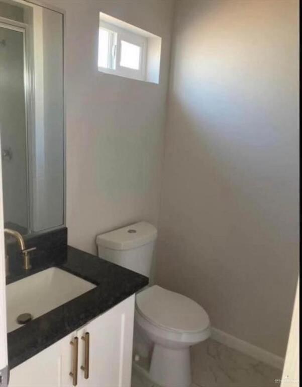 Bathroom featuring vanity, toilet, and tile flooring