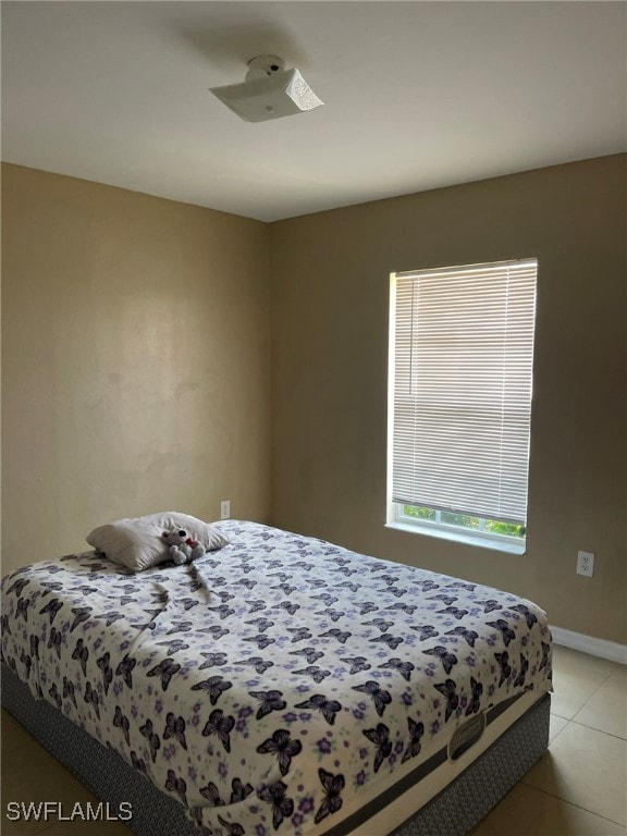 Bedroom with baseboards and light tile patterned f