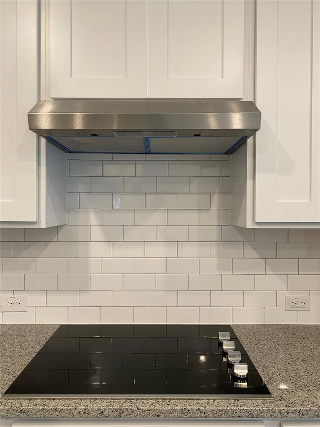 Details with black electric cooktop, white cabine