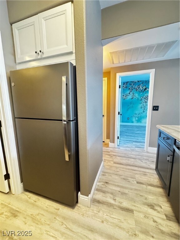 Kitchen featuring refrigerator, light wood finishe