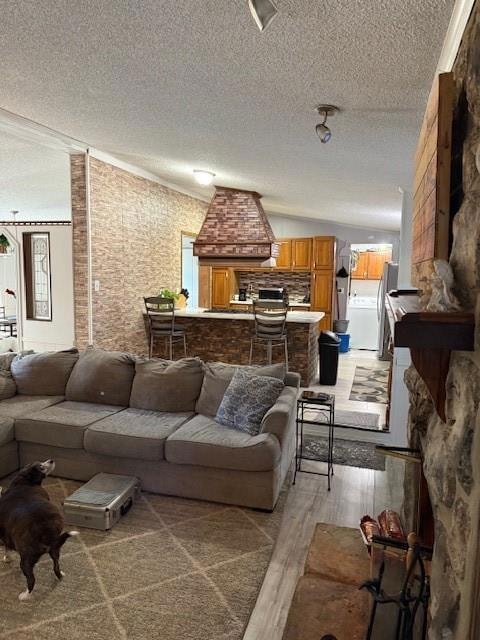 Living area featuring a textured ceiling, light wood-style floors, and washer / dryer