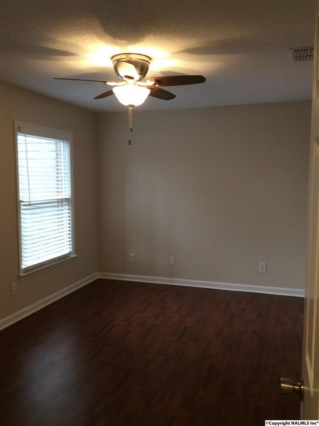 This Bedroom is to the left of the foyer and features the wood flooring and a full bath  and large closets, as well as a new fan light fixture and wood blinds ....