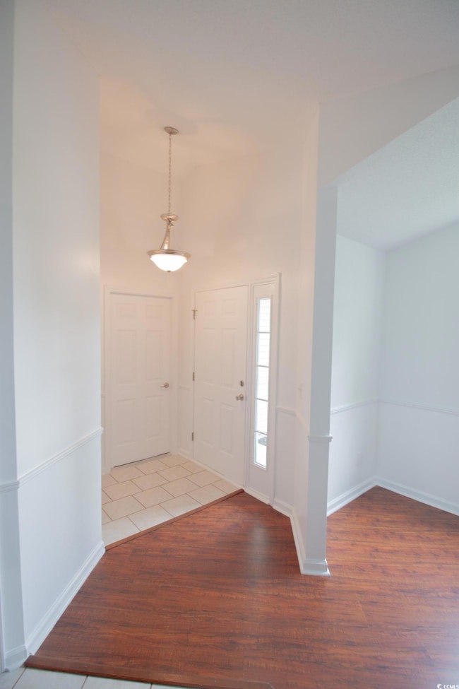 Entryway with wood finished floors and baseboards