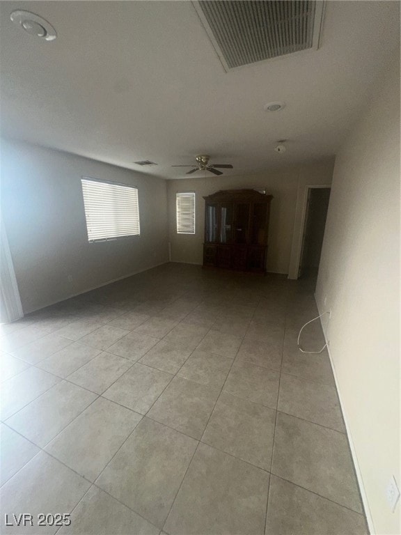 Empty room with light tile patterned floors and ceiling fan