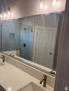 Primary bathroom with marble finish shower, double vanity, and separate toilet.