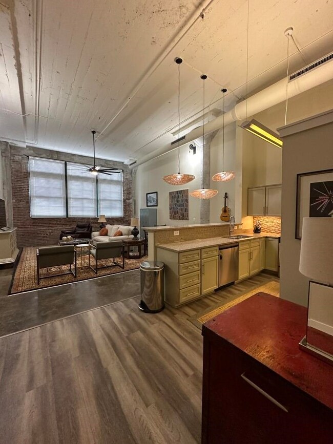 Kitchen with sink, stainless steel dishwasher, ceiling fan, and light hardwood / wood-style floors