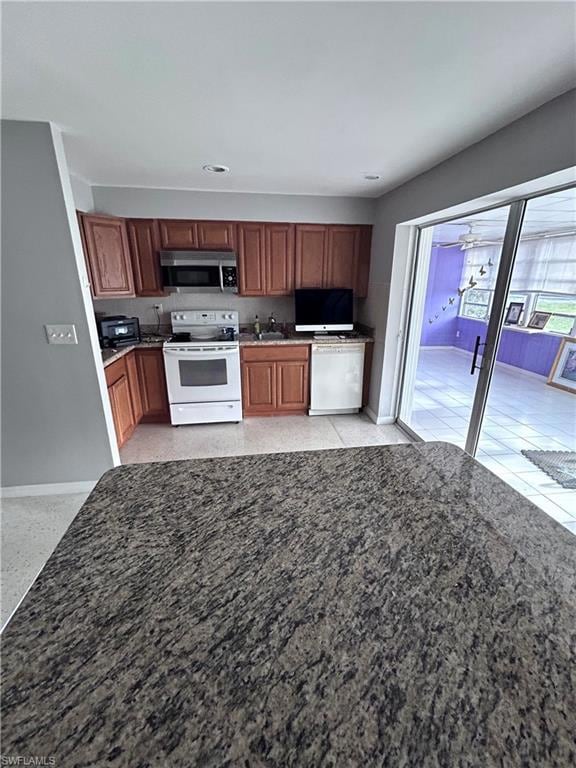 Kitchen with white appliances, ceiling fan, and si
