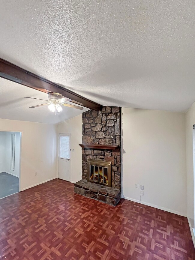 Unfurnished living room featuring ceiling fan, bas