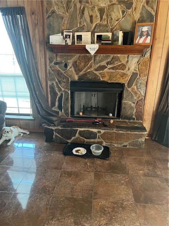 Room details featuring a stone fireplace and tile 