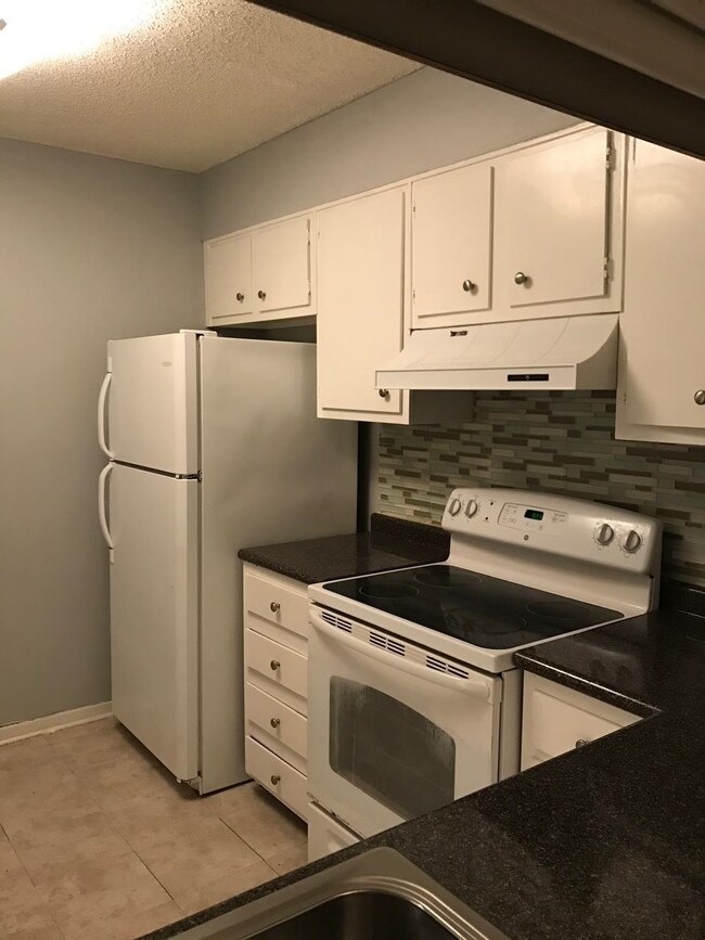 Kitchen with tasteful backsplash, white appliances