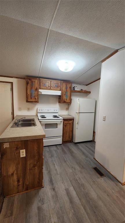 Kitchen with exhaust hood, sink, stove, dark hardw