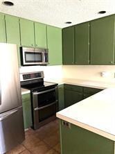 Kitchen featuring green cabinets, stainless steel