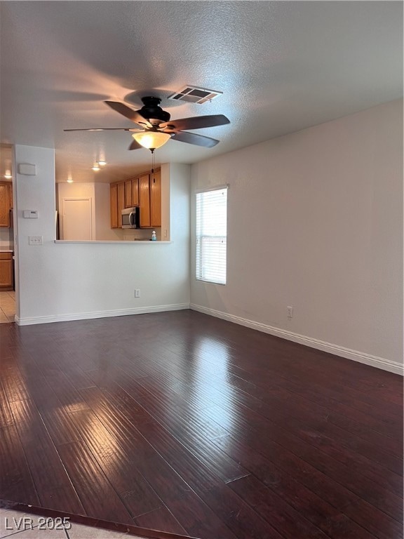 Unfurnished living room with a ceiling fan, dark w