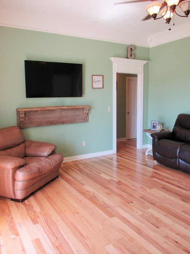 Ceiling fan lighting and heavy trim work in the living room
