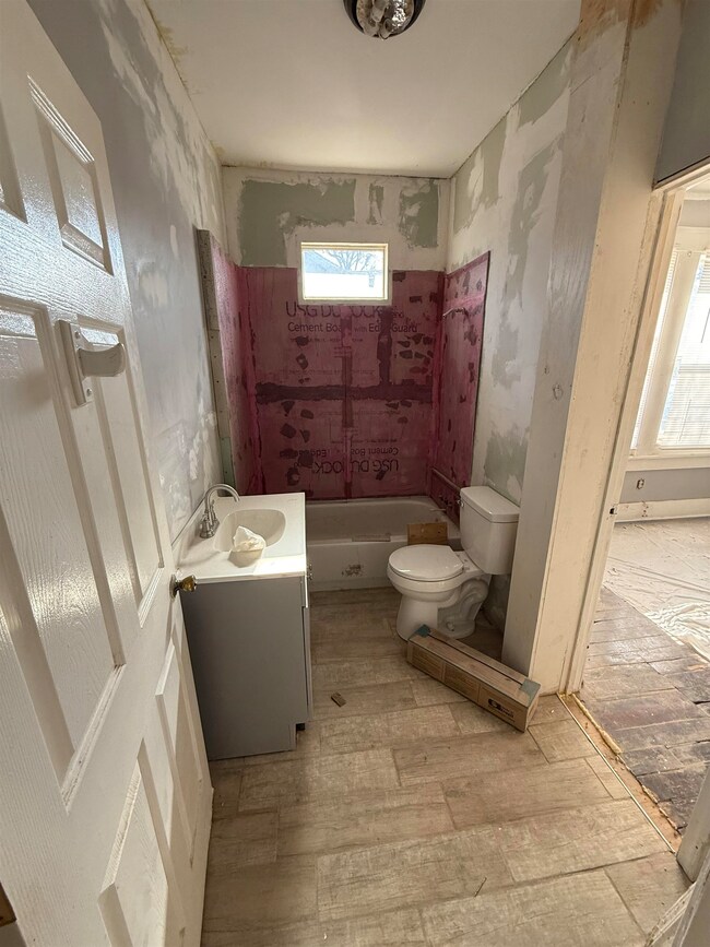 Full bathroom featuring vanity, hardwood / wood-st