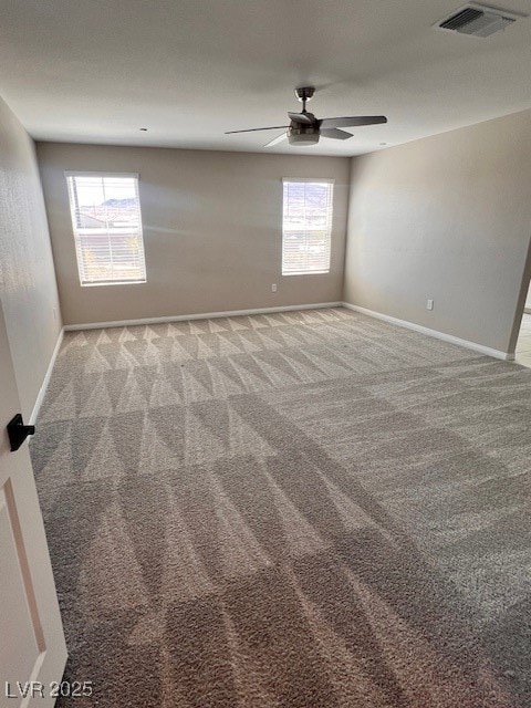 Empty room featuring carpet floors, baseboards, vi