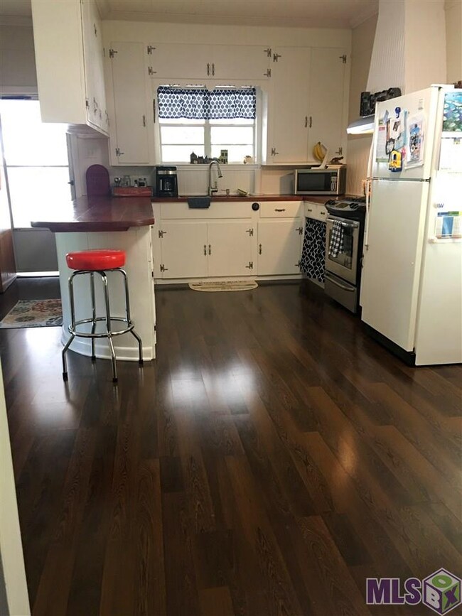 Updated kitchen has new counter tops, sink, gas st
