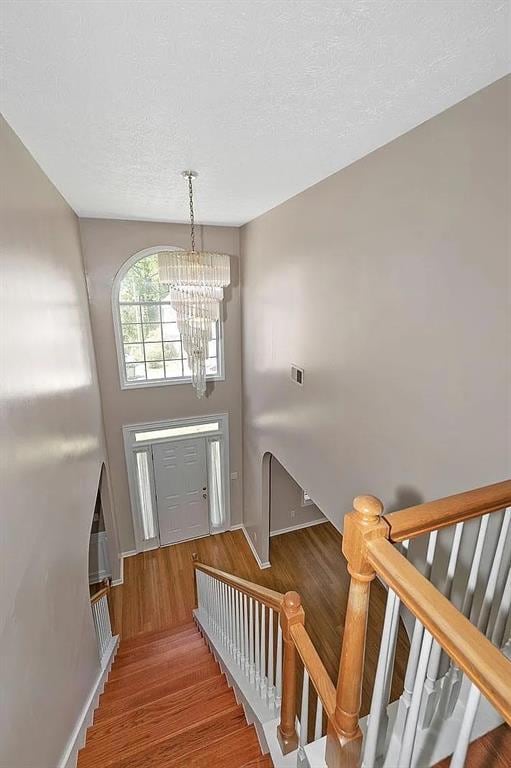 Foyer entrance with wood finished floors, a chande