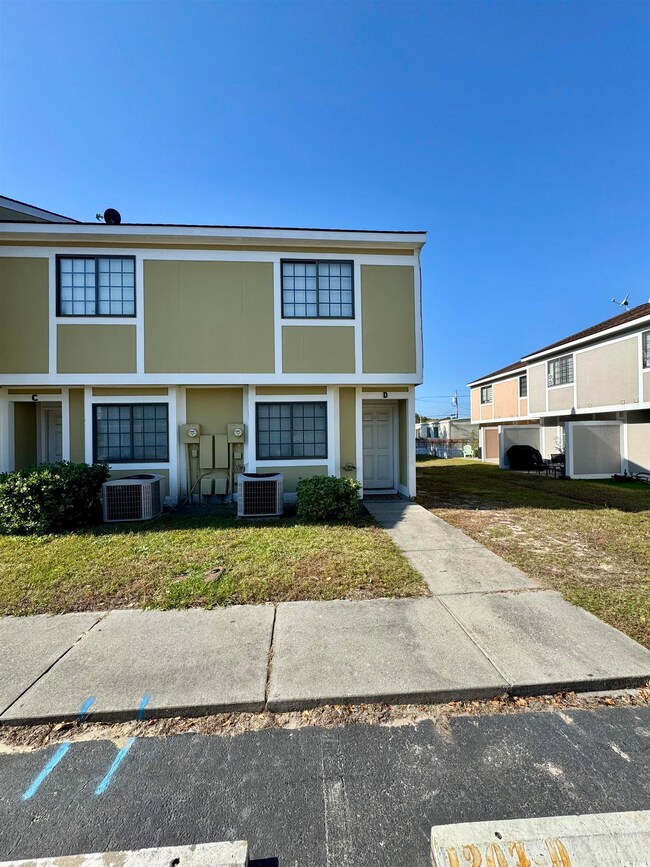 View of front of house featuring stucco siding and a front lawn