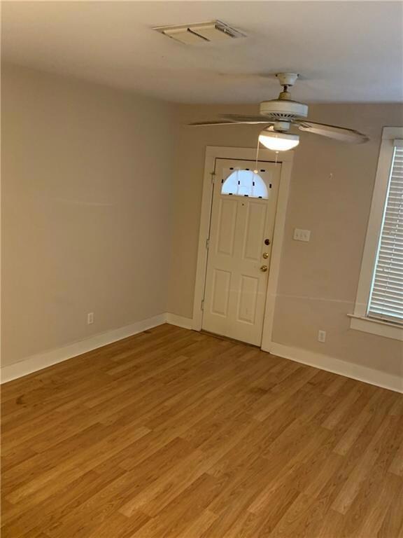 Foyer entrance with ceiling fan, baseboards, visi