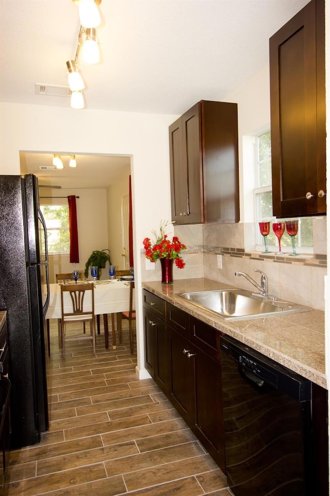 Kitchen with a sink, dark wood finished floors, b