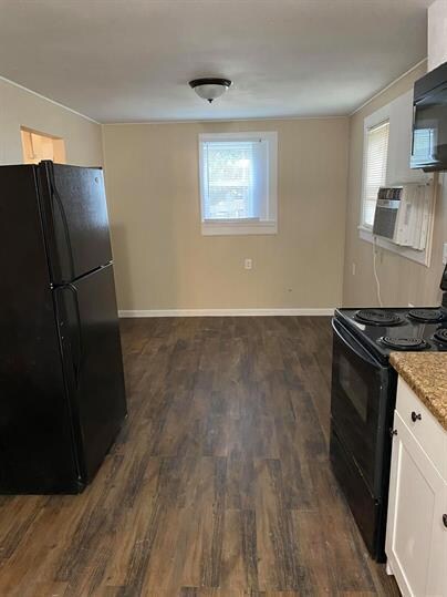 Kitchen with light stone counters, plenty of natu