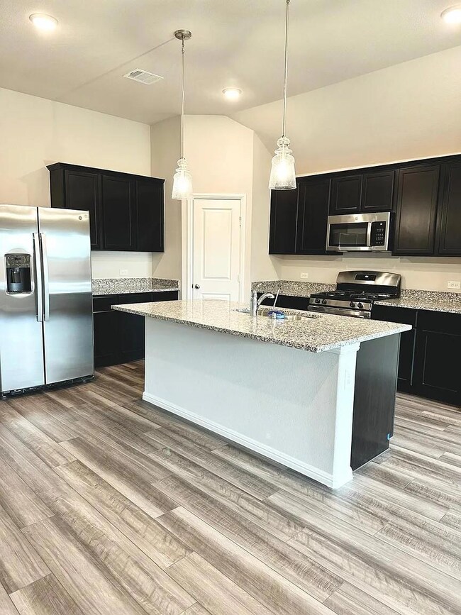 Kitchen featuring visible vents, a sink, dark cabi