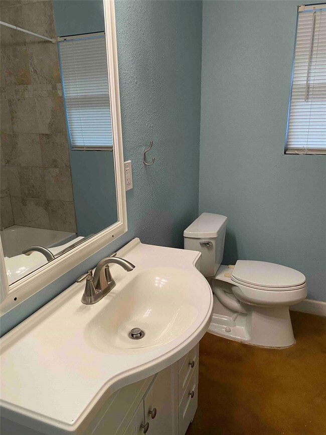 Full bathroom featuring toilet, vanity, and baseb