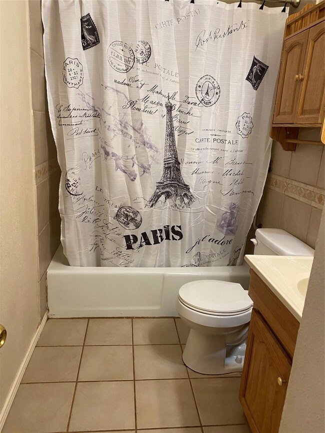 Full bathroom featuring vanity, toilet, tile patte