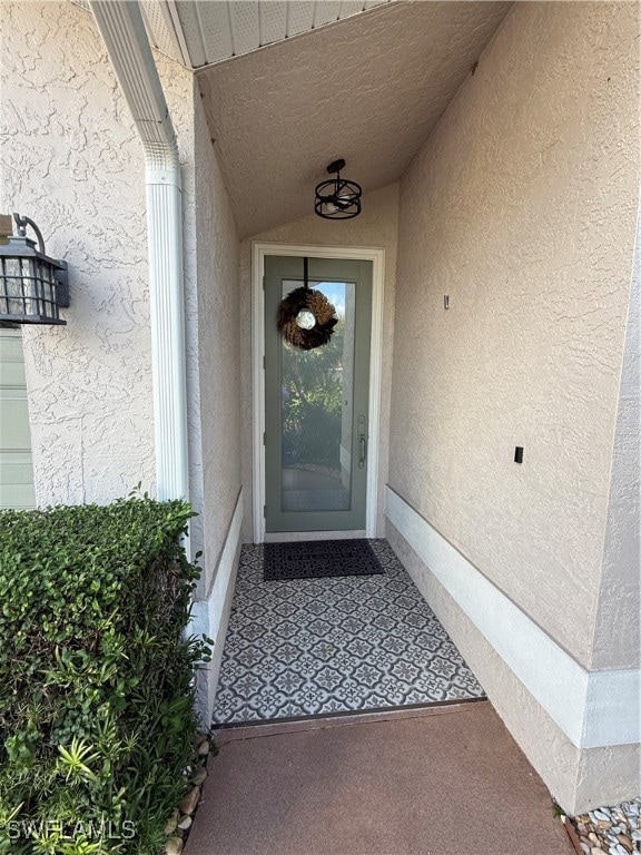 View of exterior entry with stucco siding
