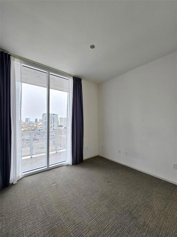 Unfurnished room featuring baseboards, floor to c