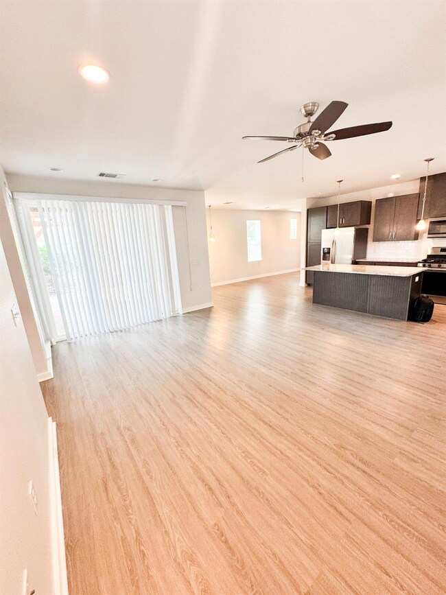 Unfurnished living room with a ceiling fan, light