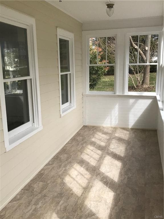 WELCOMING PORCH WITH PLENTY OF WINDOWS TO LET THE 
