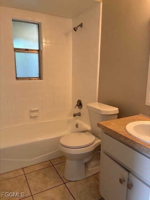 Bathroom featuring vanity, washtub / shower combination, and light tile patterned flooring