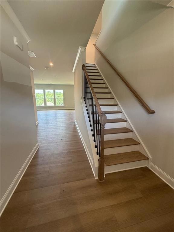 Staircase with recessed lighting and wood finished floors