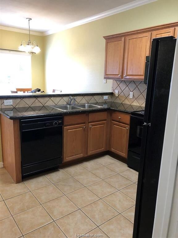 Kitchen featuring light tile patterned floors, a s