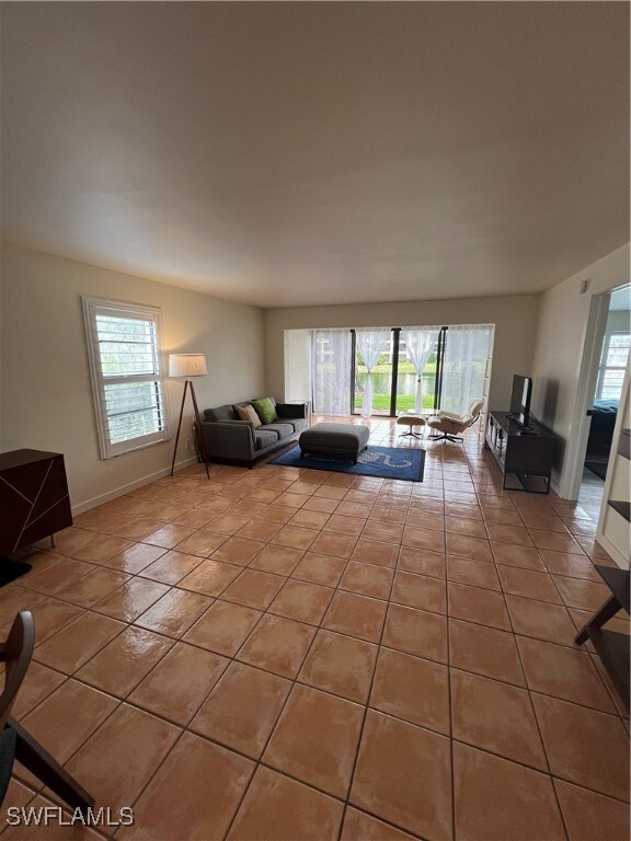 Kitchen with light tile patterned floors, fridge,